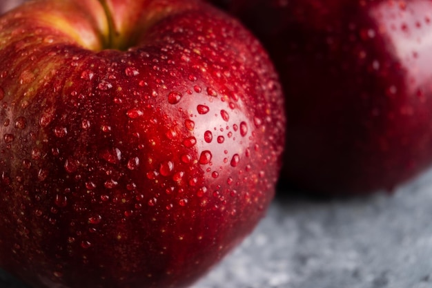 Natte en sappige verse rode appels met waterdruppels op een donkere achtergrond met Detailopname. Selectieve focus