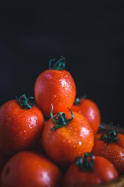 Natte tomaten tegen een zwarte achtergrond