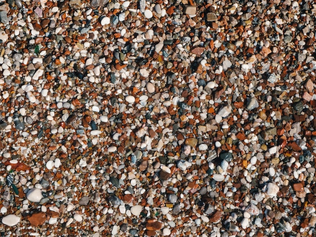 Natte zeekiezelstenen of rotsenstenen als natuurachtergrond mooie zeestenen van verschillende groottekleuren