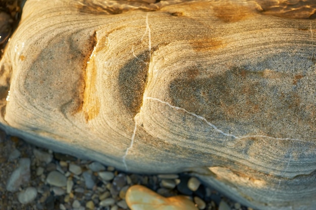 Natte zeestenen die op het strand liggen