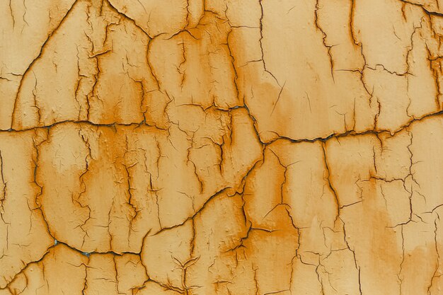 Natural abstract background of textured cracked wall of orange color.