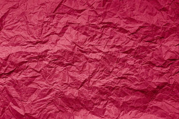 Natural abstract textured background of wrinkled paper of viva magenta color of the year 2023