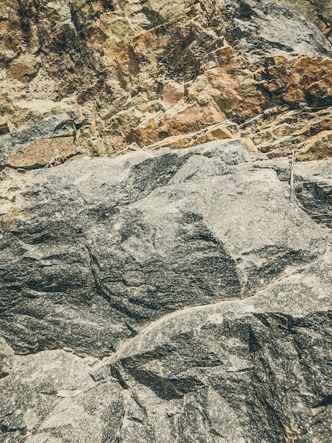 Photo natural background closeup edged shabby cliff cracks graybrown stone rock texture of mountains vintage and faded matt style colour in tinted photo concept of geolog mountaineering or hard work