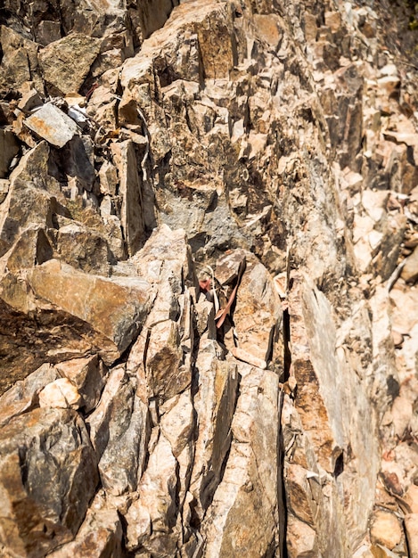 Natural background closeup edged shabby cliff cracks graybrown\
stone rock texture of mountains vintage and faded matt style colour\
in tinted photo concept of geolog mountaineering or hard work