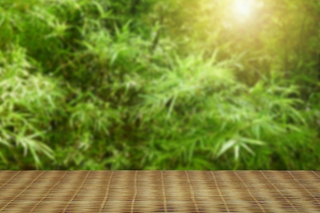 Natural bamboo matwith foliage bokeh background. Ready for product display montage.