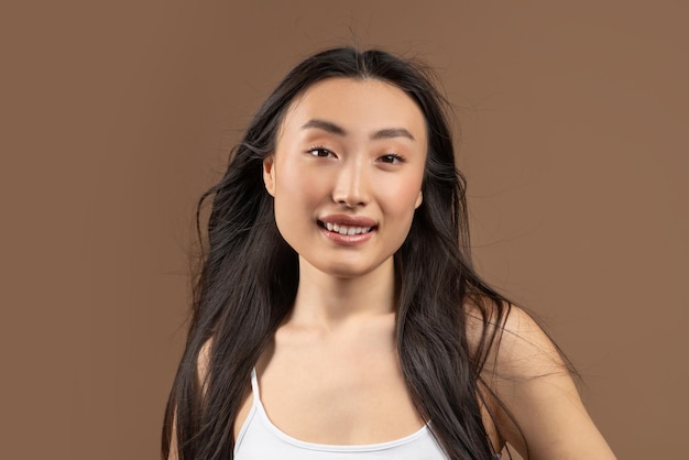 Natural beauty concept happy young asian lady with smooth perfect skin and silky hair posing over