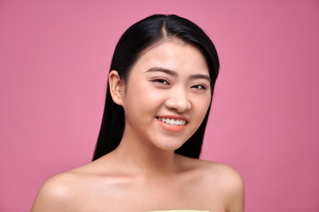 ピンクの背景の若いアジア人の女性の自然な美しさの概念