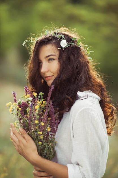 自由な楽しみの概念で屋外の花の花束を持つ自然の美しさの女の子。ポートレート写真