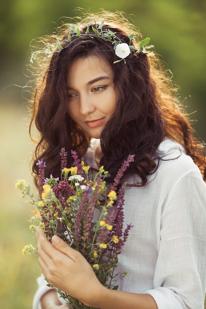 自由の楽しみの概念で屋外の花の花束を持つ自然の美しさの少女。