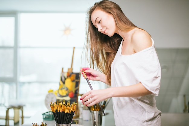 Natural beauty teacher painter in her studio preparing to an art class