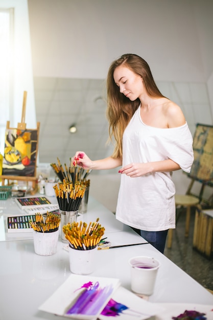Natural beauty teacher painter in her studio preparing to an art class