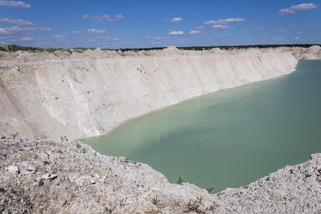 Natural blue water at the foot of a steep quarry