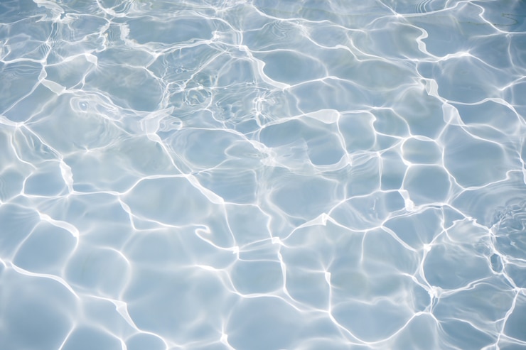 明るい太陽光の反射を伴う自然な青い水面