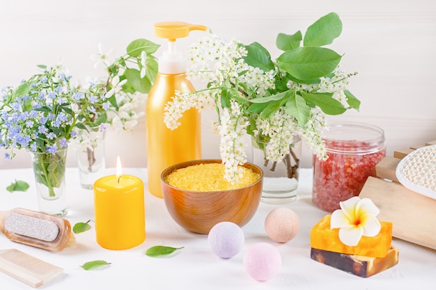 Natural body care products and accessories lay out with flowers and leaves