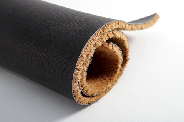 ナチュラル・ブラウン・ココナッツ・ファイバー・ドアマット (Natural Brown Coconut Fiber Doormat) はエントランスの外側に自然乾燥したカーペットと汚れを敷き白い背景のファイバーとベースの詳細クローズアップです