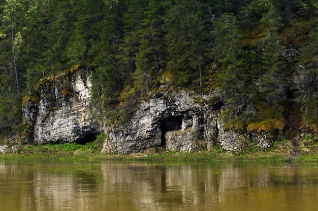 Natural cave in the limestone cliff of the river bank