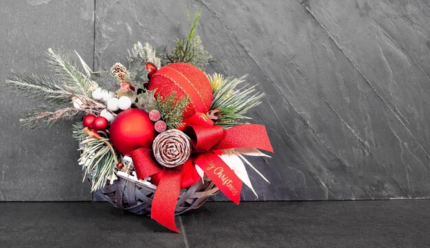 Natural Christmas wreath with sleigh, with cones and red balls on grey background with copy space