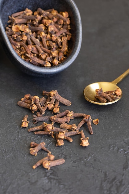 Photo natural clove spice on dark concrete background