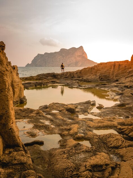 Natural coastal landscape with tide pools and the Ifaz rock in the background at sunset