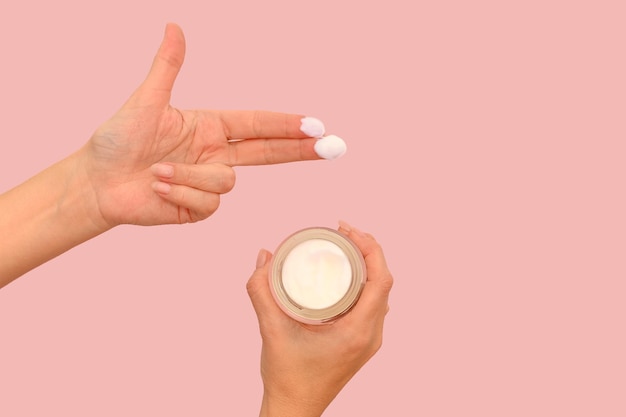 Natural cosmetic cream on hands Skin cream On a pink background