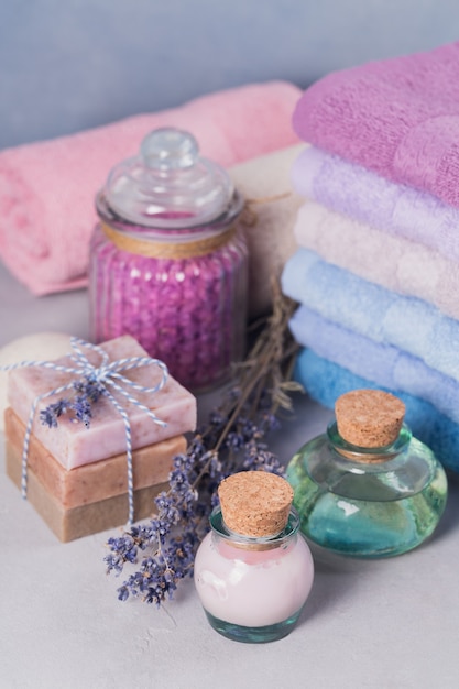 Olio cosmetico naturale, crema, sale marino e sapone naturale fatto a mano con lavanda su sfondo chiaro. cura della pelle sana. aromaterapia, spa e concetto di benessere