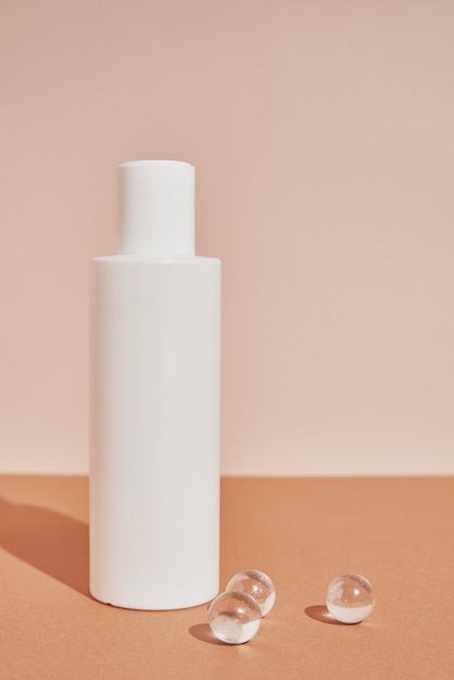 Белая бутылка натурального косметического продукта на пастельном фоне