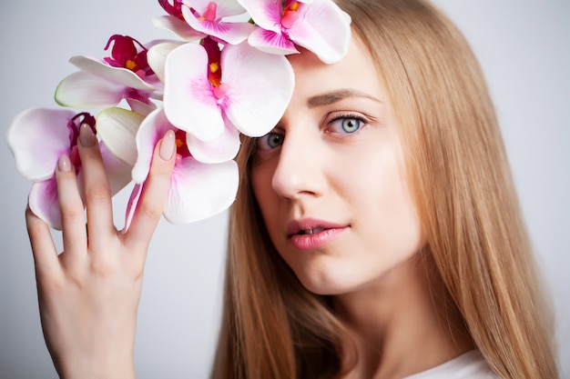 Natural cosmetics, beautiful woman face with orchid.
