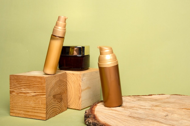 Natural creams in golden bottles on forest materials