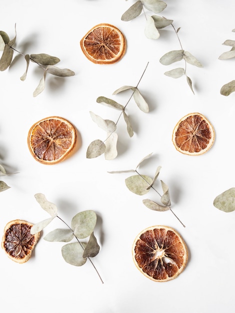 Natural creative composition of dry branches of eucalyptus and orange dry slices 
