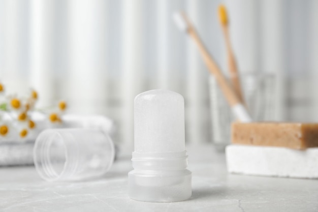 Natural crystal alum deodorant on light grey marble background