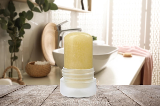 Natural crystal alum deodorant on wooden table in bathroom