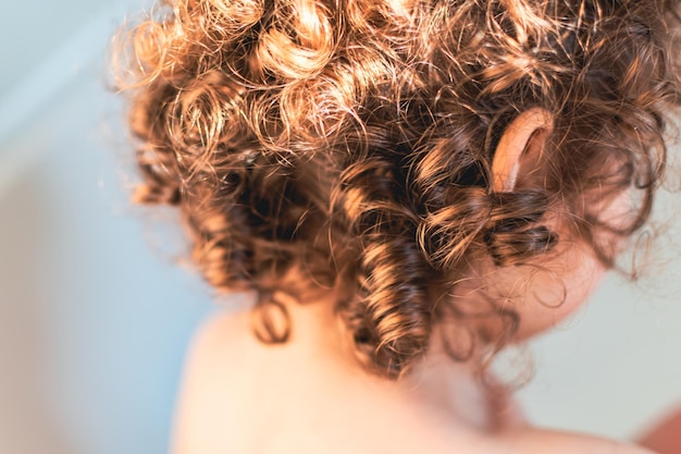 Natural curly hair little girl with light brown curls and golden reflections