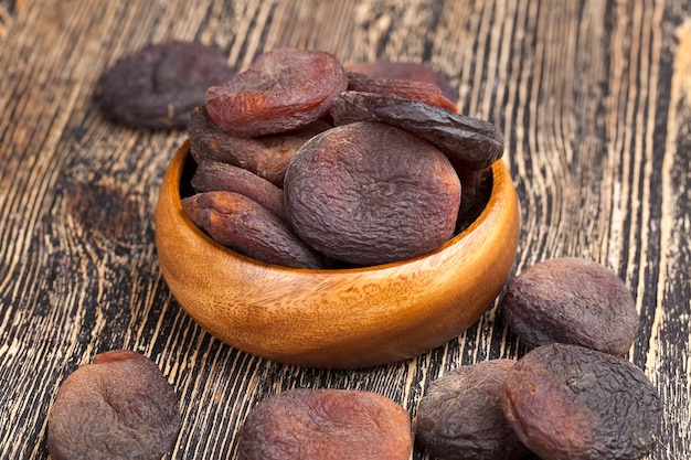 Natural dark-colored sweets made from apricot fruit, natural dried apricots in the sunlight