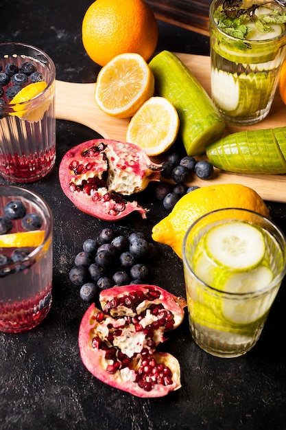 Natural detox water made from infusing berried, fruits and vegetables on dark wooden background