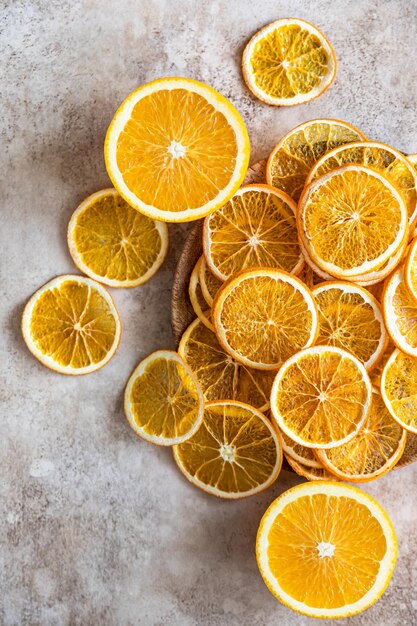 Natural dried oranges on light concrete background Sliced and dried citrus fruit