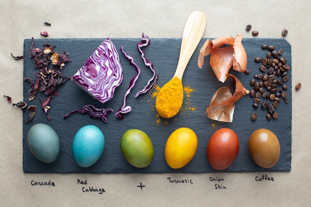 Foto colorante naturale per uova di pasqua: carcassa, cavolo rosso, curcuma, buccia di cipolla e caffè. uova di pasqua colorate fatte in casa con ingredienti