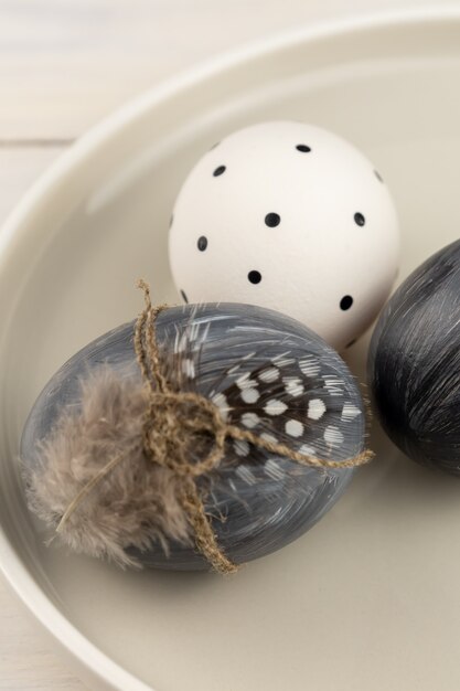 Uova di pasqua grigie tinte naturali in un piatto su fondo di legno rustico. punto di vista ad alto angolo.