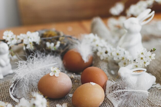 Natural easter eggs white petals bunnies feathers on rustic linen napkin happy easter