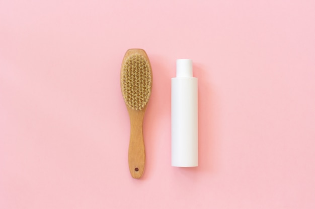 Natural eco brush and white bottle of cream for massage, peeling and body care.