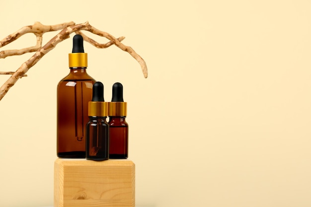 Natural essential oil, serum in a brown glass bottle with a pipette on a wooden podium with a copy space. Alternative medicine, aromatic beauty skincare product. Liquid fragrant product. Copy space.