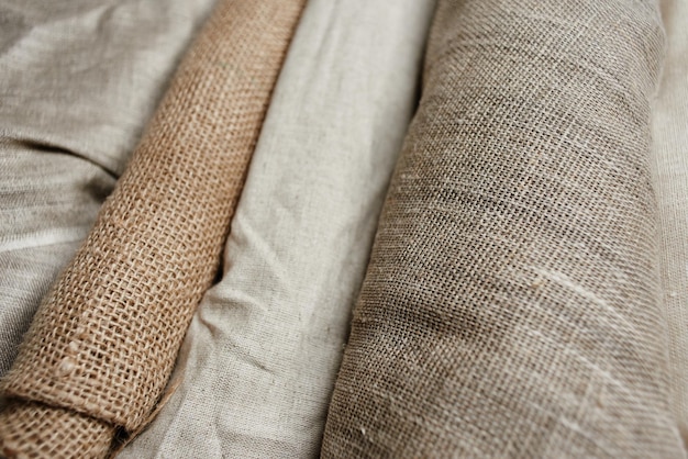 Natural fabrics from organic colors of flax and cotton in rolls, homespun textile handmade. Burlap and canvas for eco, rustic, boho, hygge decor