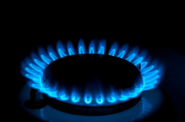 Natural gas burning a blue flames on black background