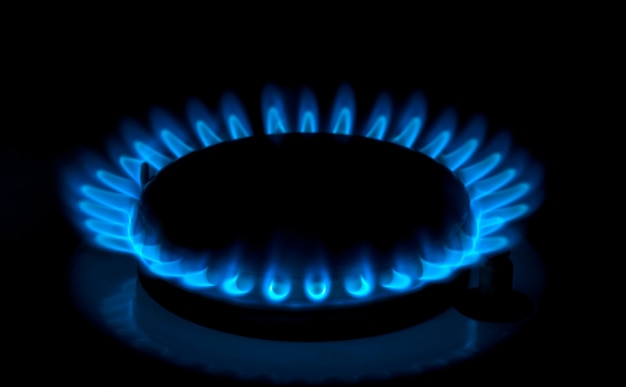 Natural gas burning a blue flames on black background