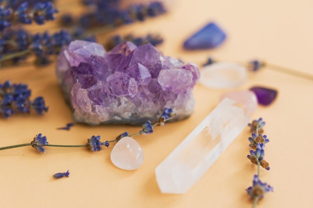Natural gemstones and dry lavender flowers on a light background close up