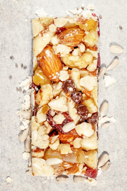 Photo natural granola cereal bar with nuts seeds oats raisins and honey on a white pergament paper