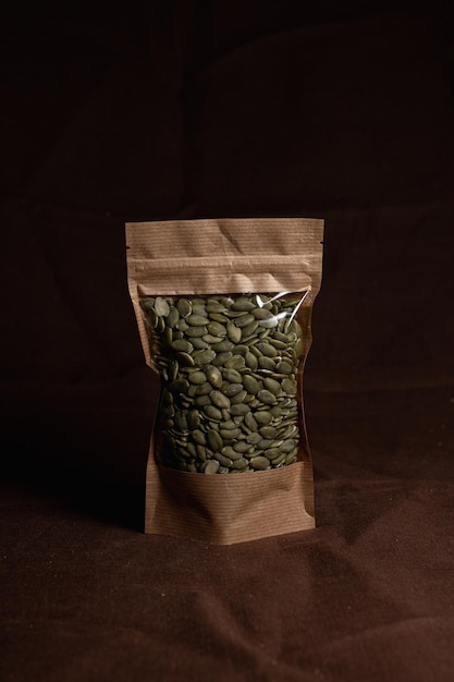 Natural green pumpkin seeds packed in eco craft paper bag on table