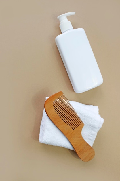 Natural hair care products, hairbrush, towel. top view.\
shampoo, mask, balm. flatlay