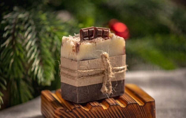 Foto sapone al cioccolato naturale fatto a mano su un piatto di sapone in legno organico