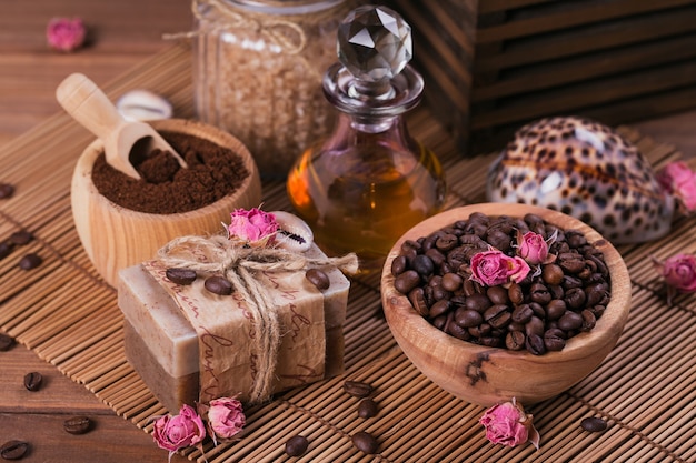天然の手作り石鹸、芳香族化粧品オイル、素朴な木製の背景にコーヒー豆と海の塩。健康的なスキンケア。サウナとスパのコンセプト。