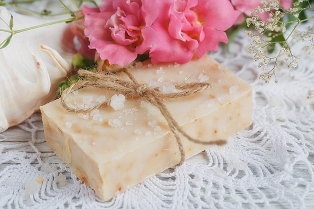 Natural handmade soap and flowers on white wooden background. Spa concept.